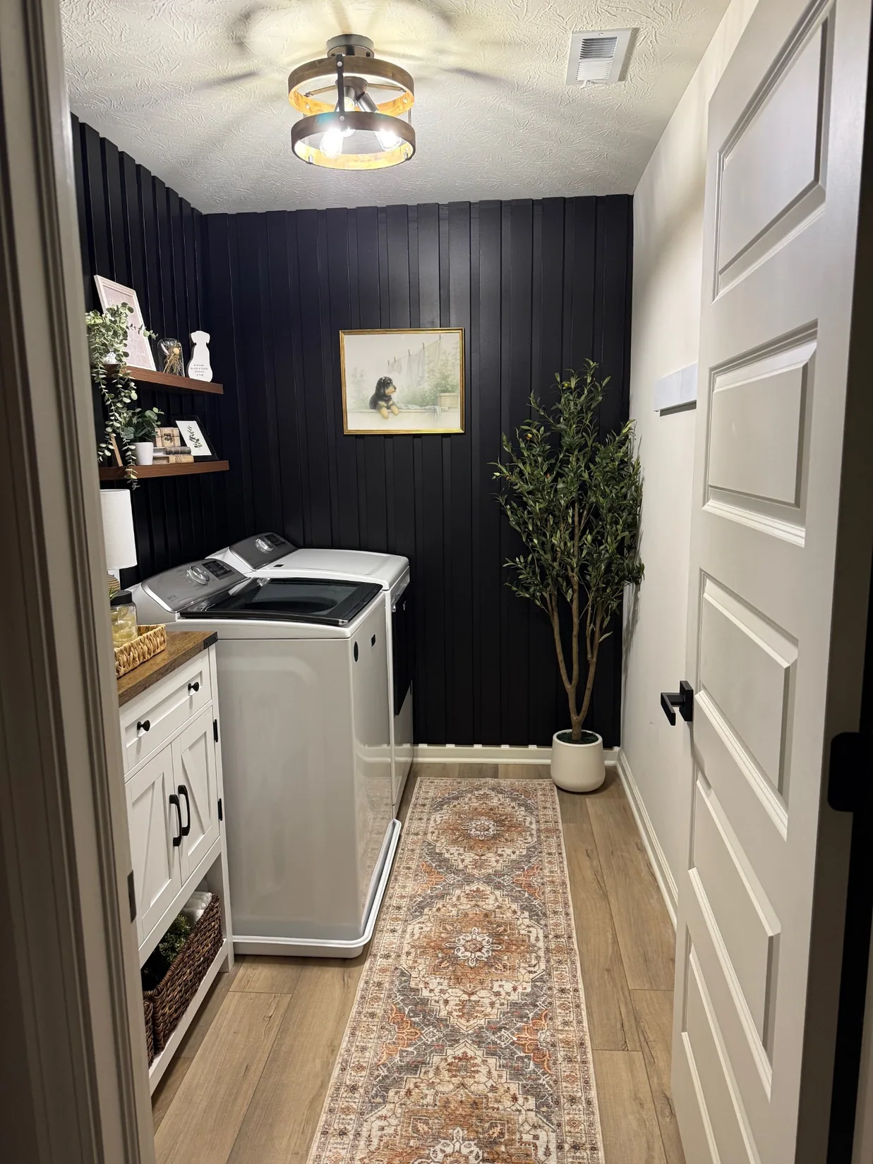 Finished laundry room with dark vertical panels and wood accents