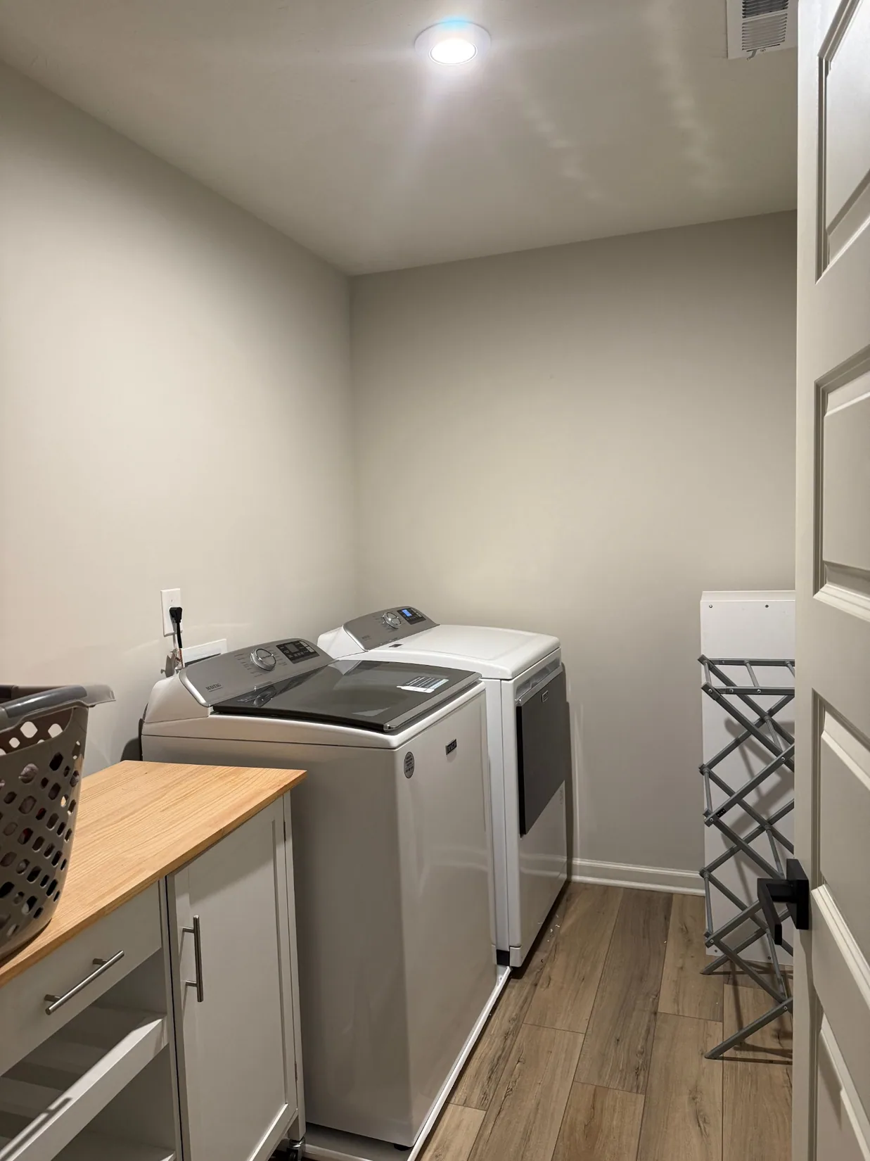 Laundry room before styling, with light walls and appliances